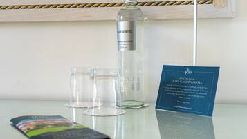 Eine Flasche San Benedetto Wasser, zwei Gläser und eine Willkommenskarte für das Elia Garden Hotel.