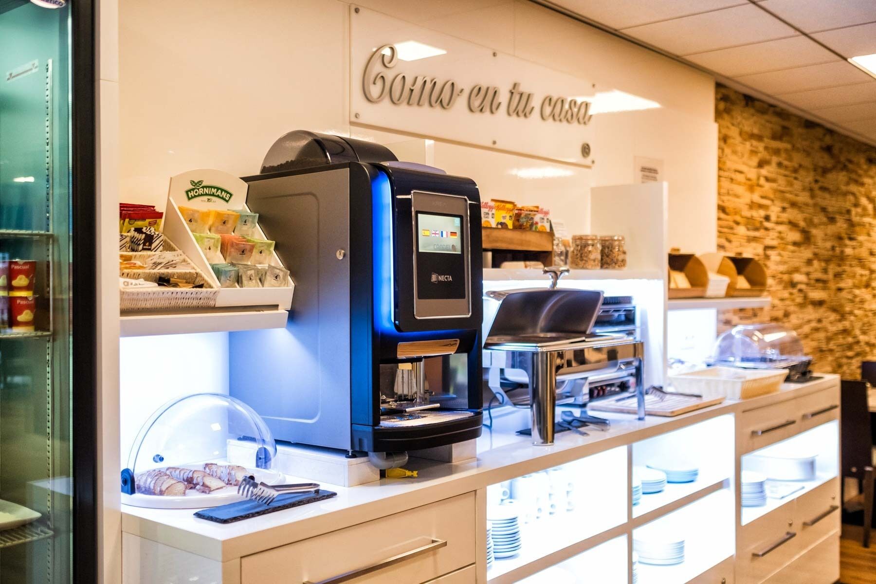Une machine à café dotée d’un écran numérique, d’un moulin à café et d’une cafetière à piston, le tout posé sur un comptoir.