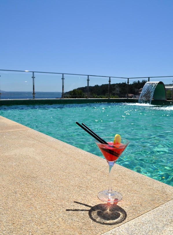Una piscina al aire libre, una piscina en la azotea, sombrillas