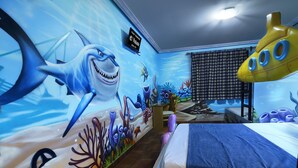 A room with a mural of an underwater scene, a bed, a desk, and a yellow submarine decoration. - El Volante (Ciempozuelos)