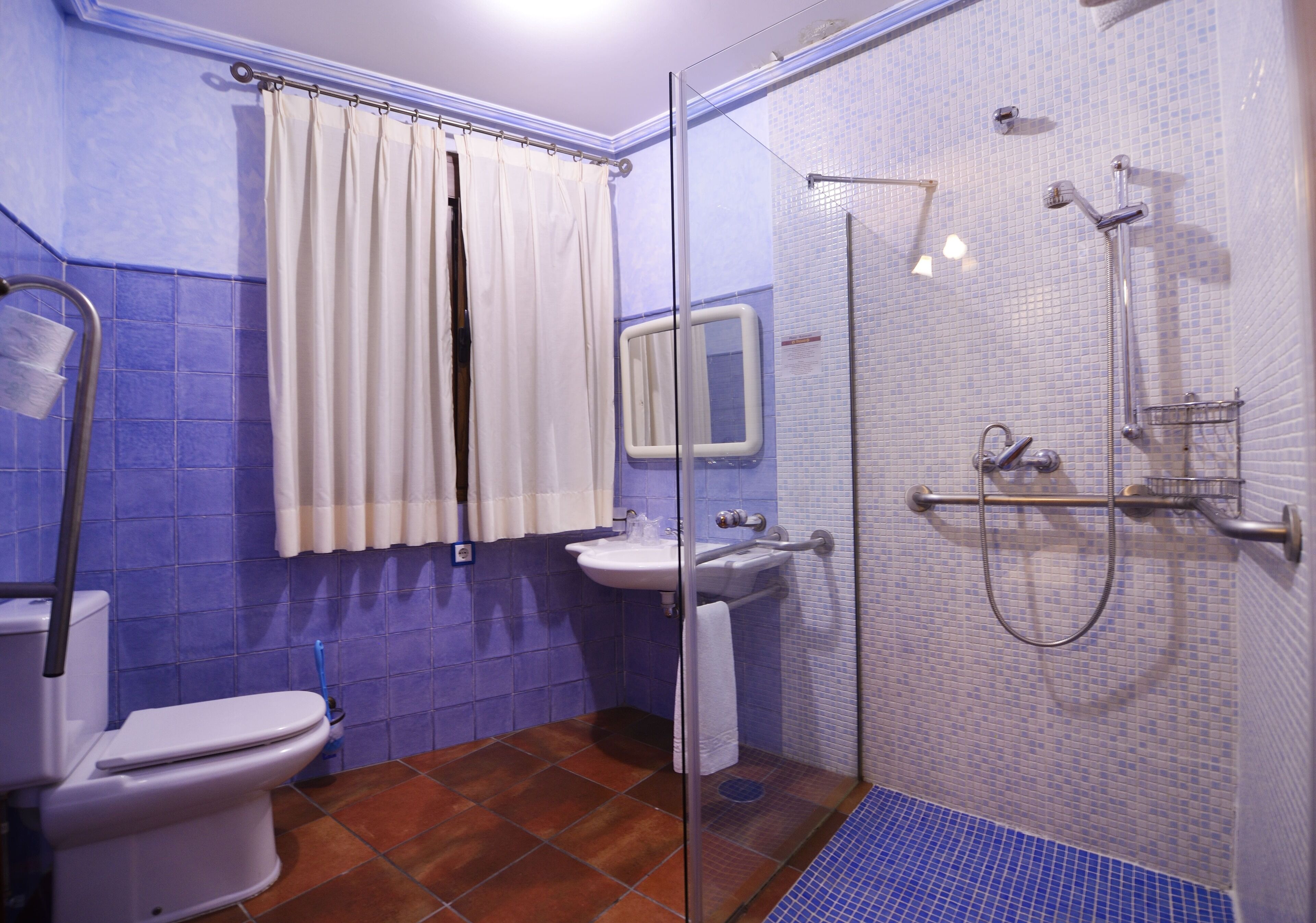 Een badkamer met toilet, wastafel en douche.