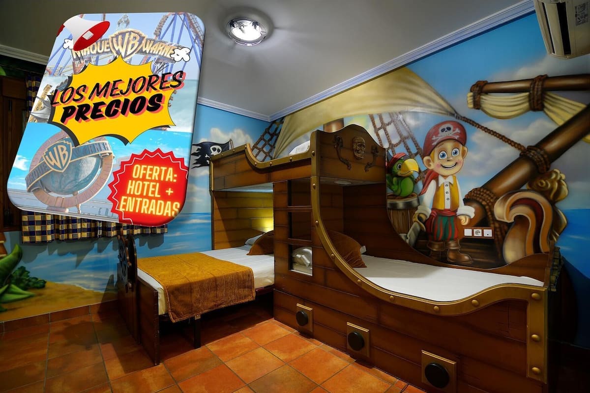 Quarto infantil com tema de pirata, incluindo uma cama beliche, uma mesinha e um mural com um navio pirata.