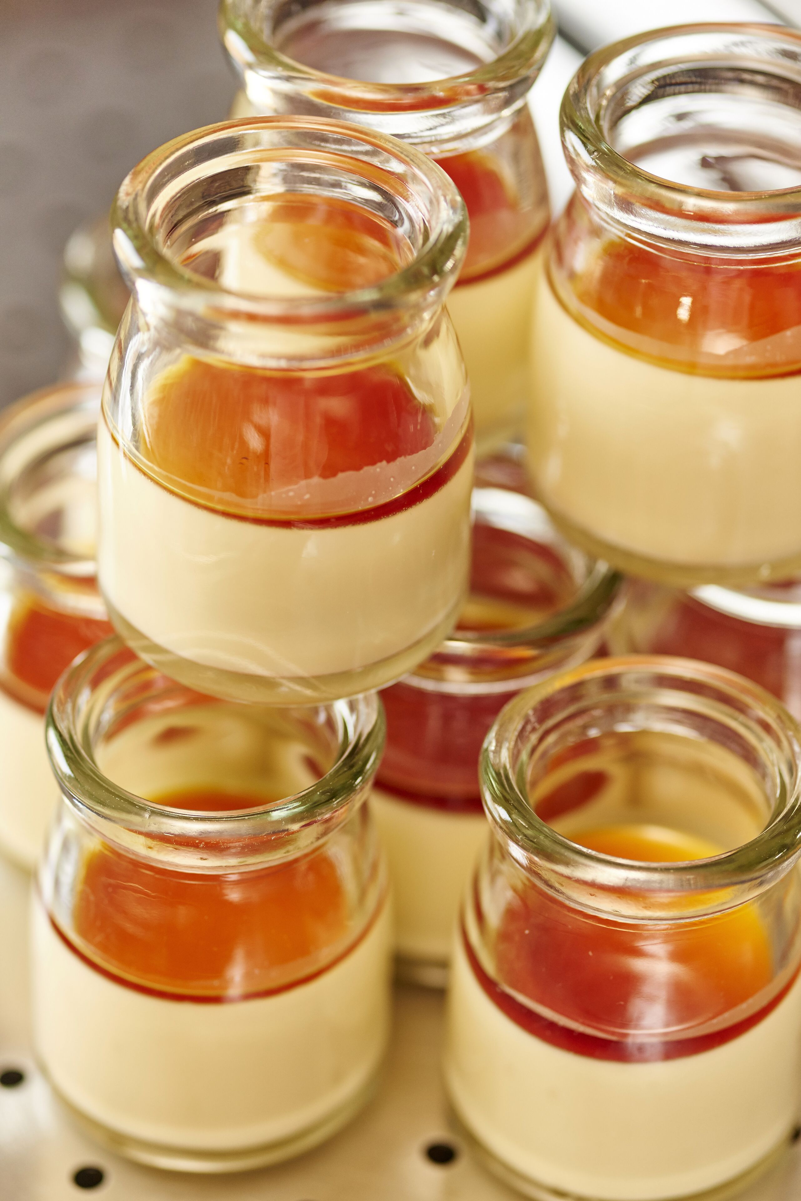 A stack of clear glass jars containing layered desserts.