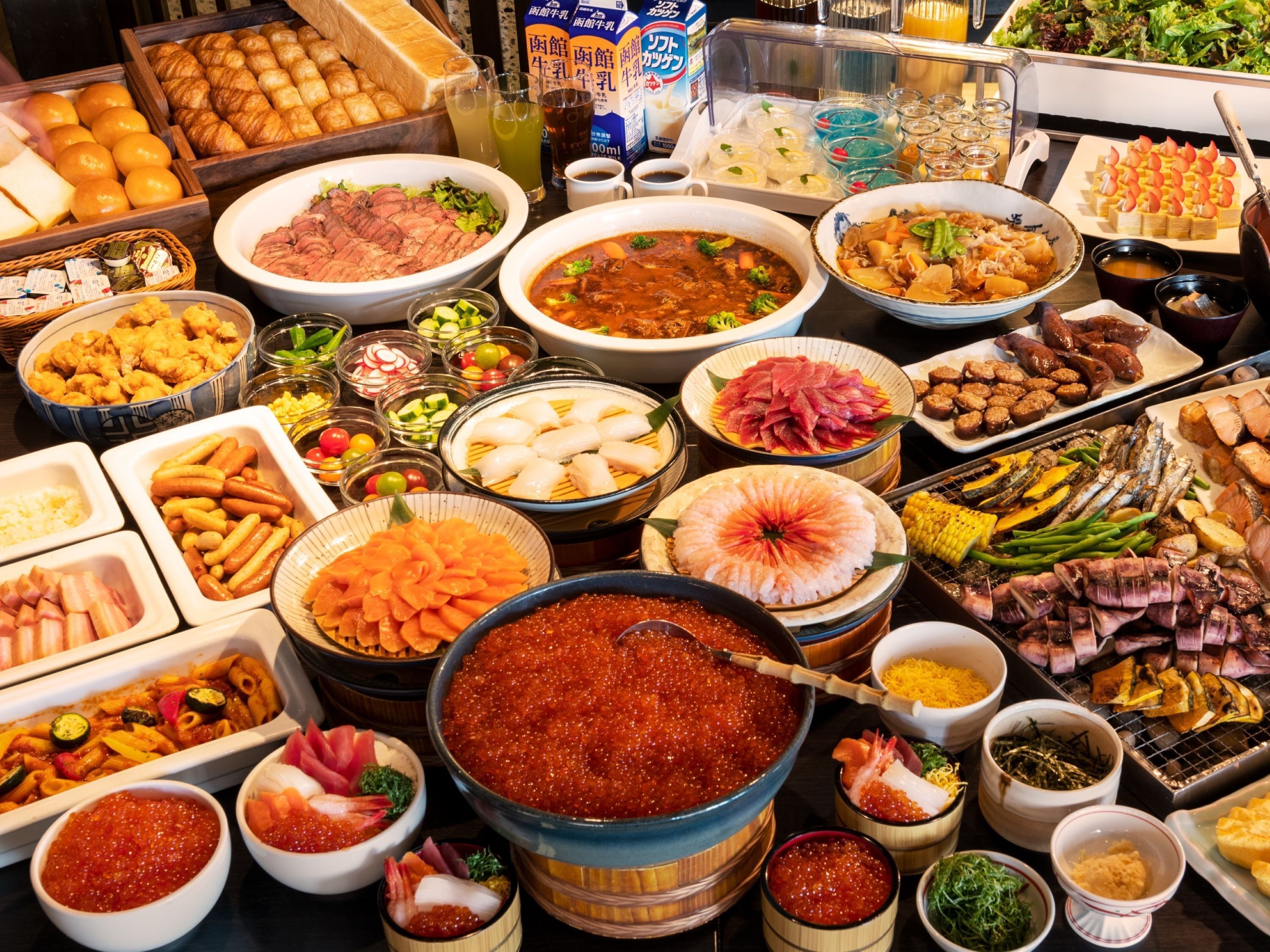 Un bufé con diversos platos, incluyendo mariscos, carnes y verduras.