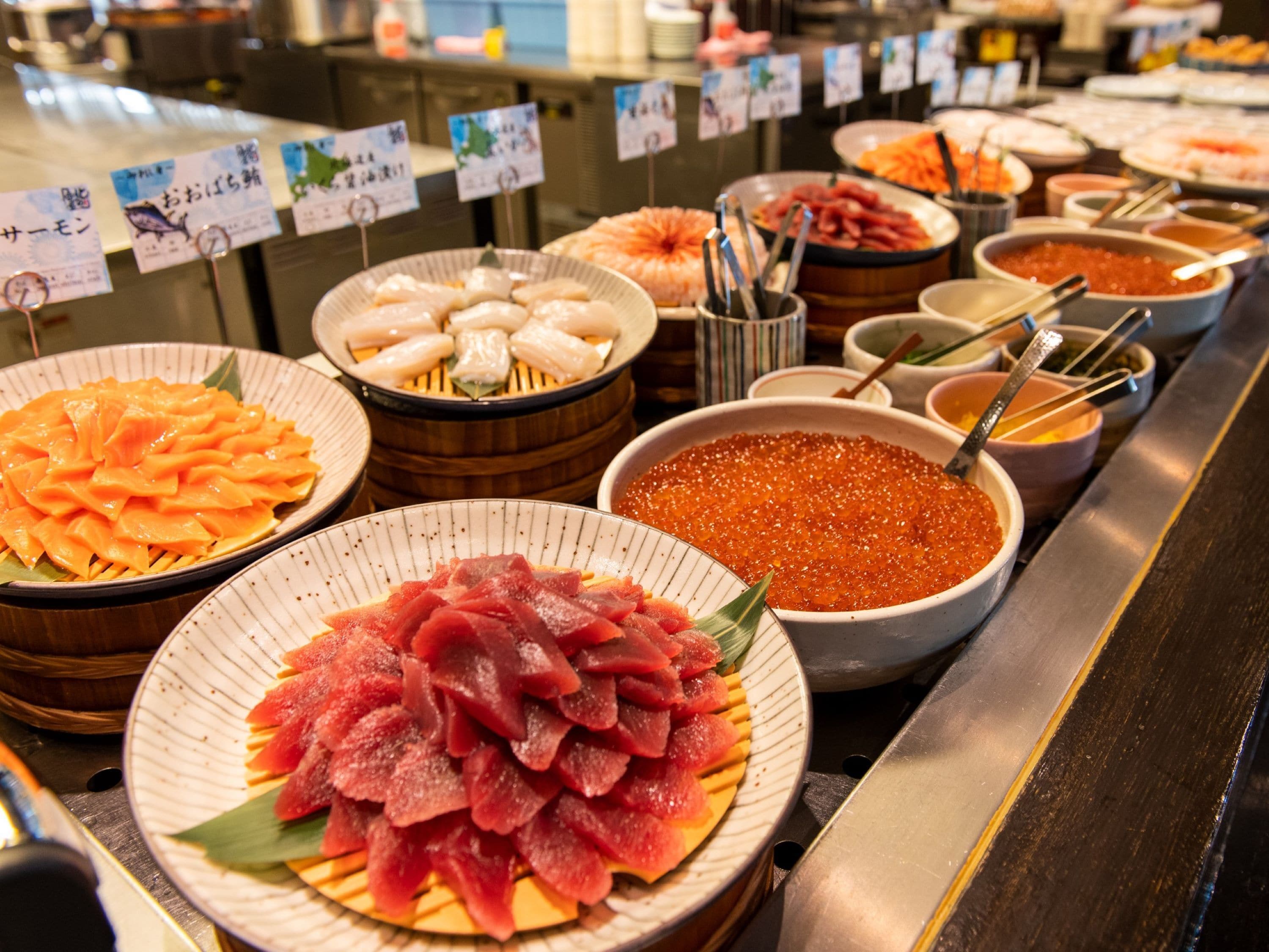A buffet with various dishes, including sashimi and seafood.