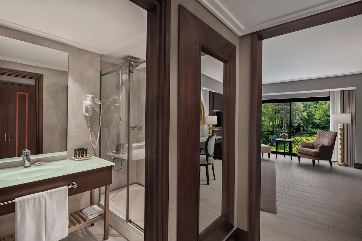 A modern bathroom with a glass shower, a vanity with a mirror, and a towel rack.