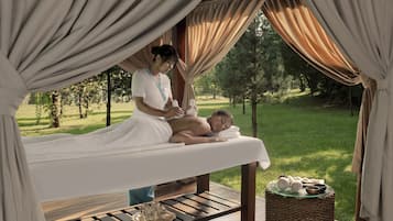 Relax in a serene outdoor massage area, complete with a massage table, stool, and tranquil surroundings.