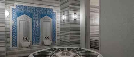 A bathroom with two sinks, a round marble bathtub, and patterned walls.