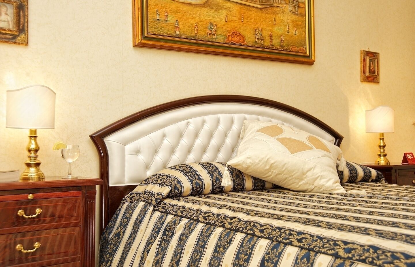 A neatly made bed with a striped bedspread and a tufted headboard.
