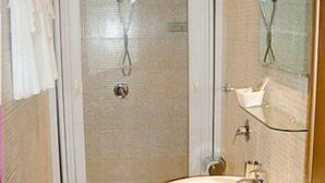 Une salle de bain avec douche, toilettes et lavabo.