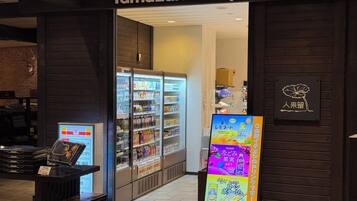 The entrance to a Yamazaki Shop with refrigerated beverage displays and a digital menu board.
