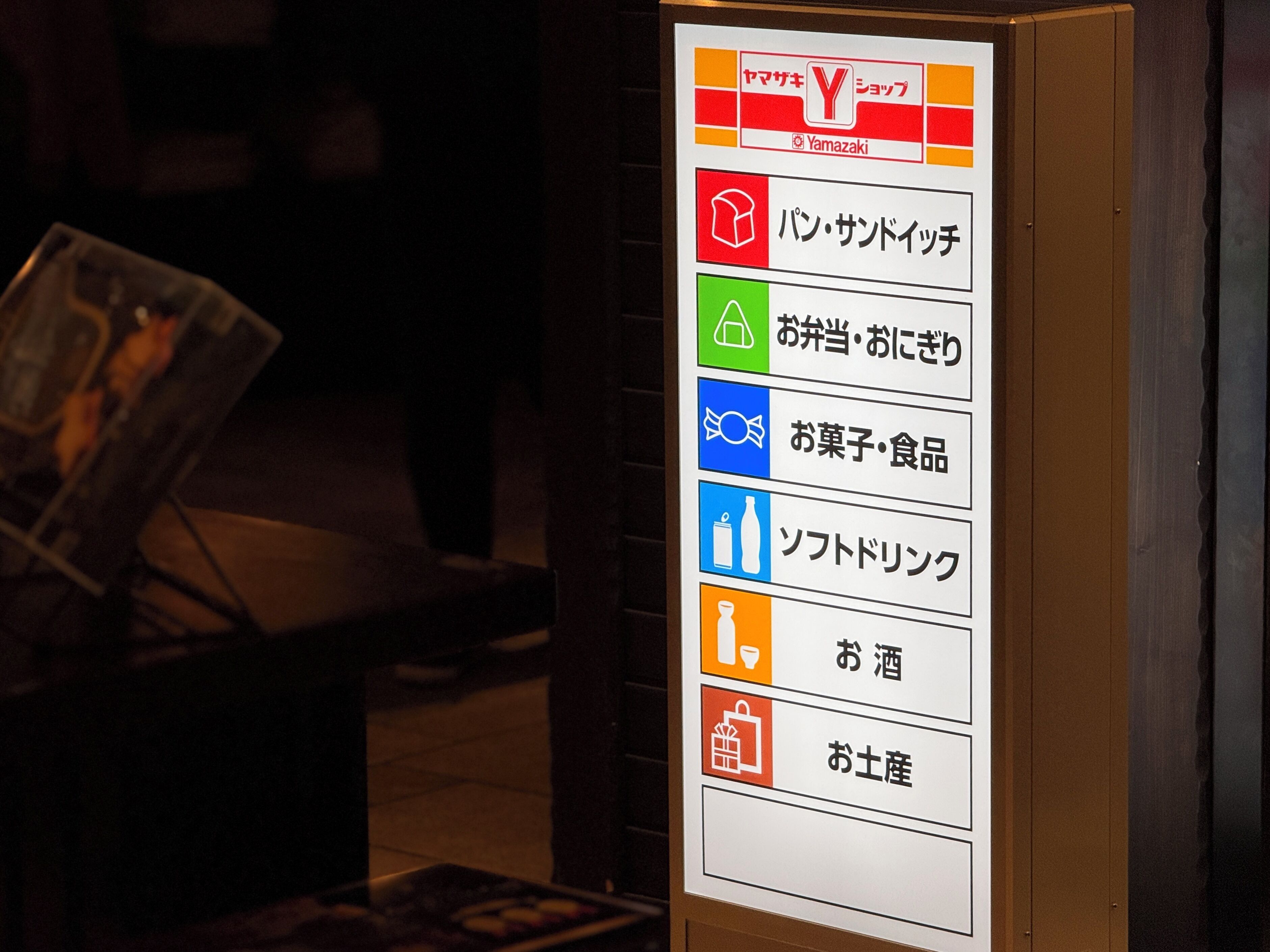 A sign with various icons and Japanese text indicating different services or amenities.