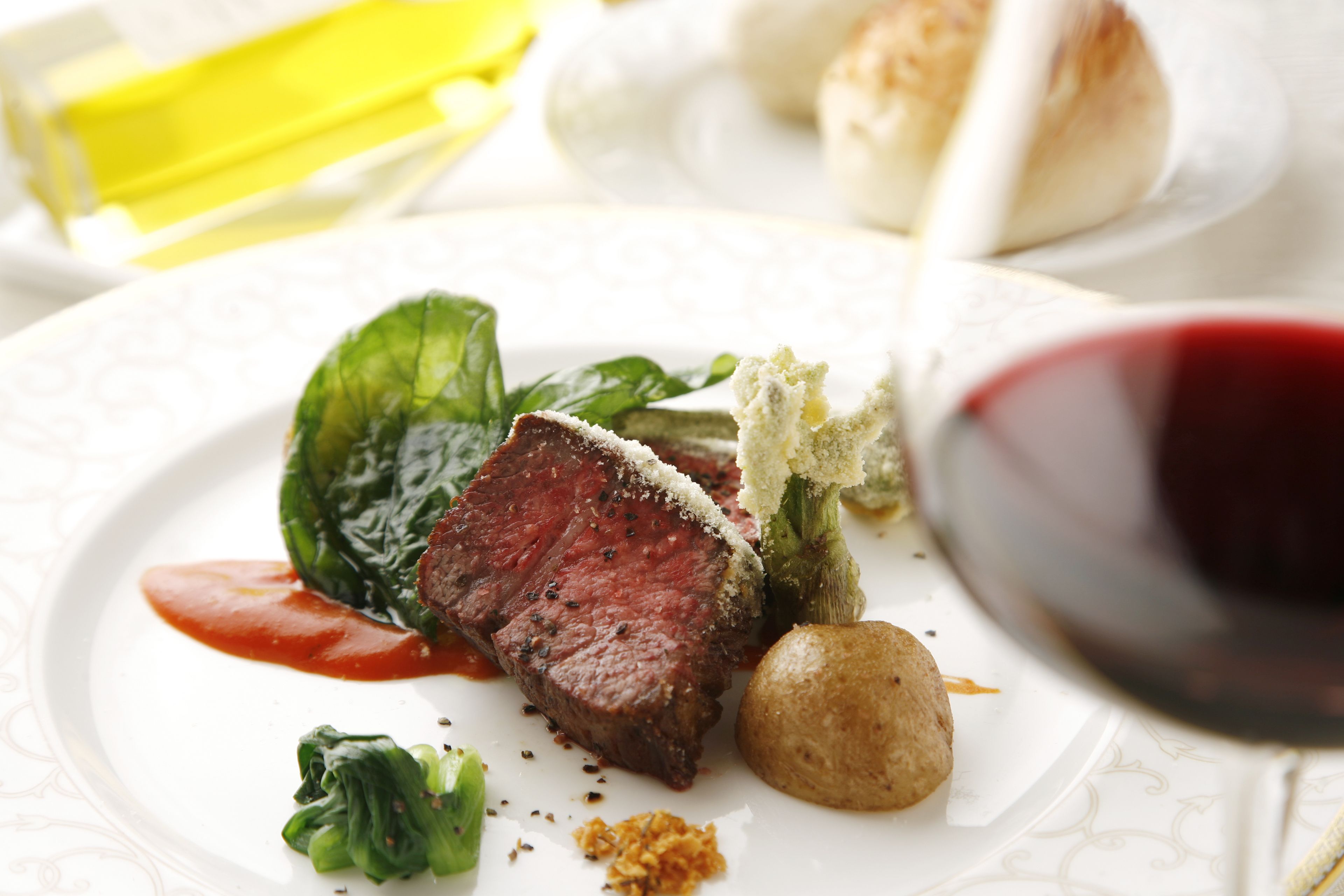 Un plato de comida con carne, verduras y salsa.