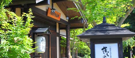 A traditional Japanese building with a wooden structure and a signboard.