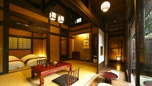 A traditional Japanese room with tatami flooring, a low wooden table, and a sliding door. - Morinoyu Izu Kogen Kiranosato (Ito)