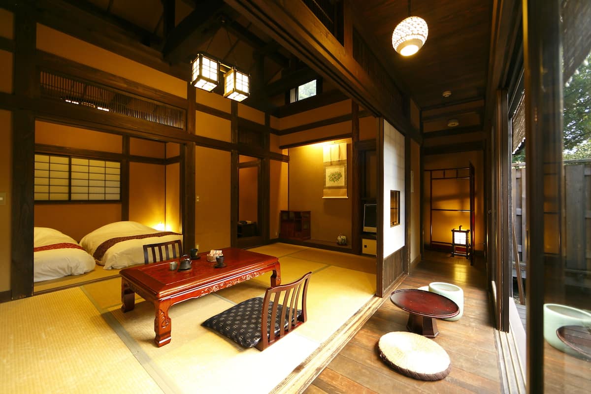 A traditional Japanese room with tatami flooring, a low wooden table, and a sliding door.