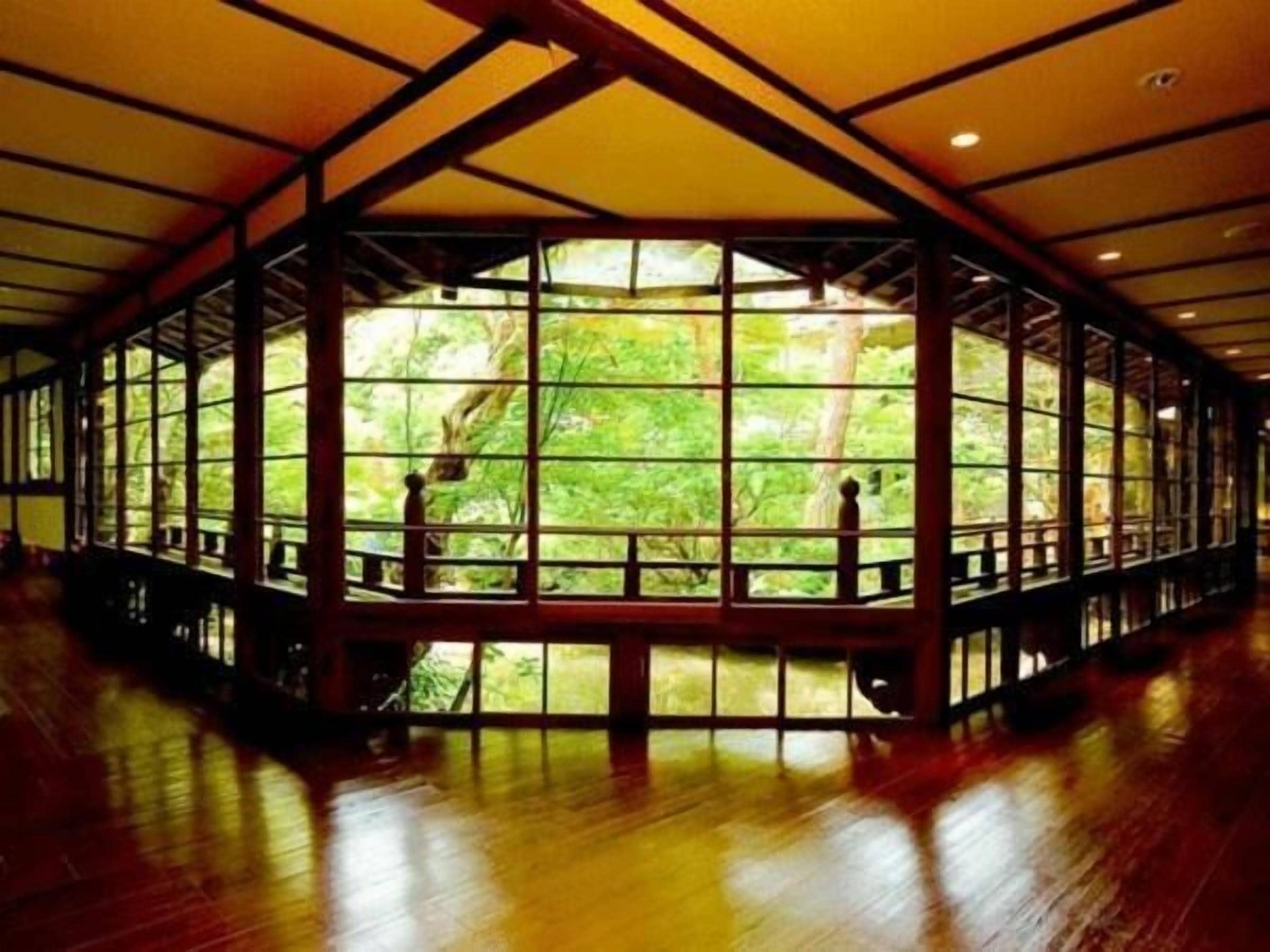 A large room with a high ceiling and a large windowed wall.