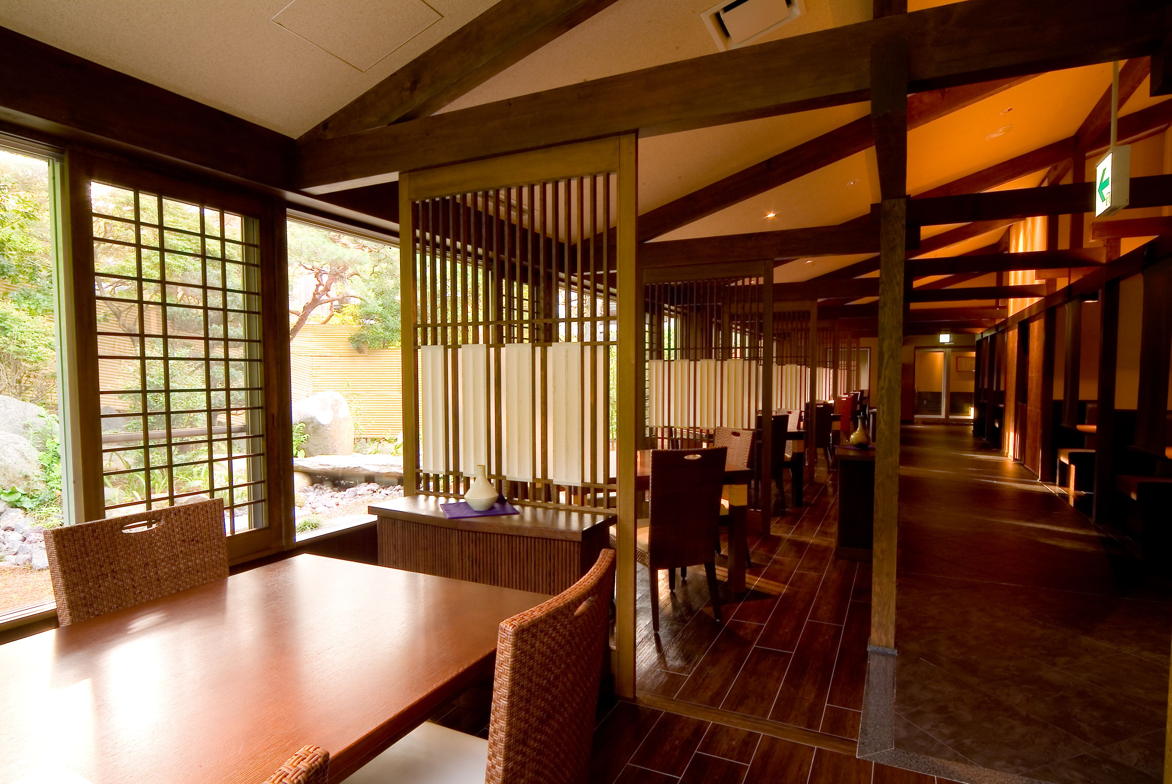 A traditional Japanese-style room with tatami flooring, low wooden tables, and shoji screens.