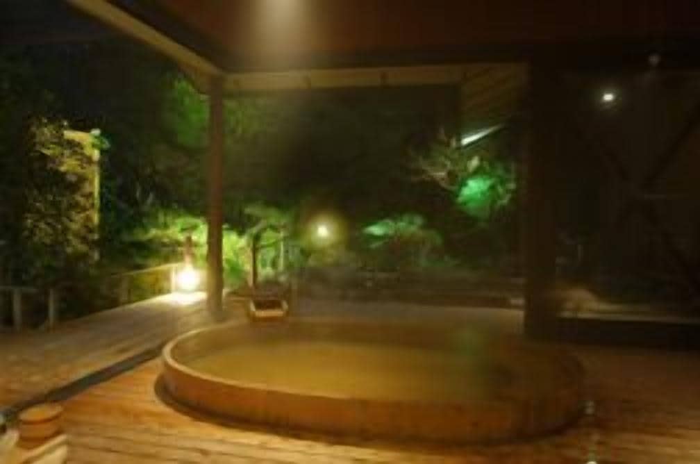Tinaco en un espacio exterior cubierto con terraza de madera y vista a árboles.