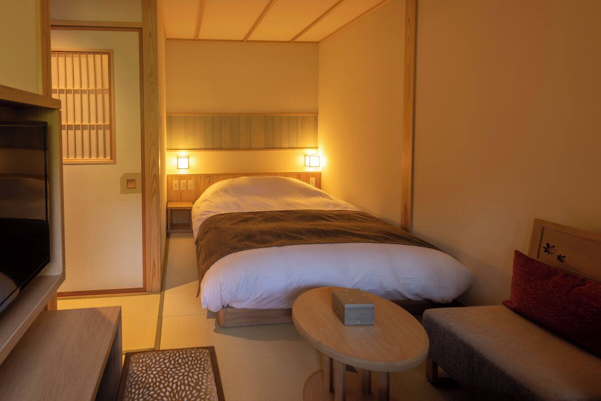 Ein Hotelzimmer mit einem Bett, einem Nachttisch und einem kleinen Tisch mit einer Schachtel.