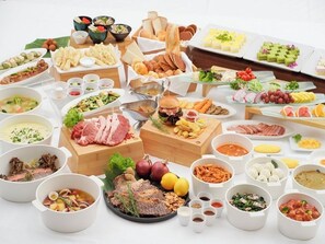 A variety of food items and dishes arranged on a table, including meats, vegetables, and condiments. - The Beach Tower Okinawa (Chatan)