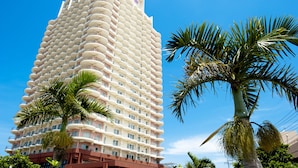 A tall, modern hotel with a unique curved facade and numerous balconies.