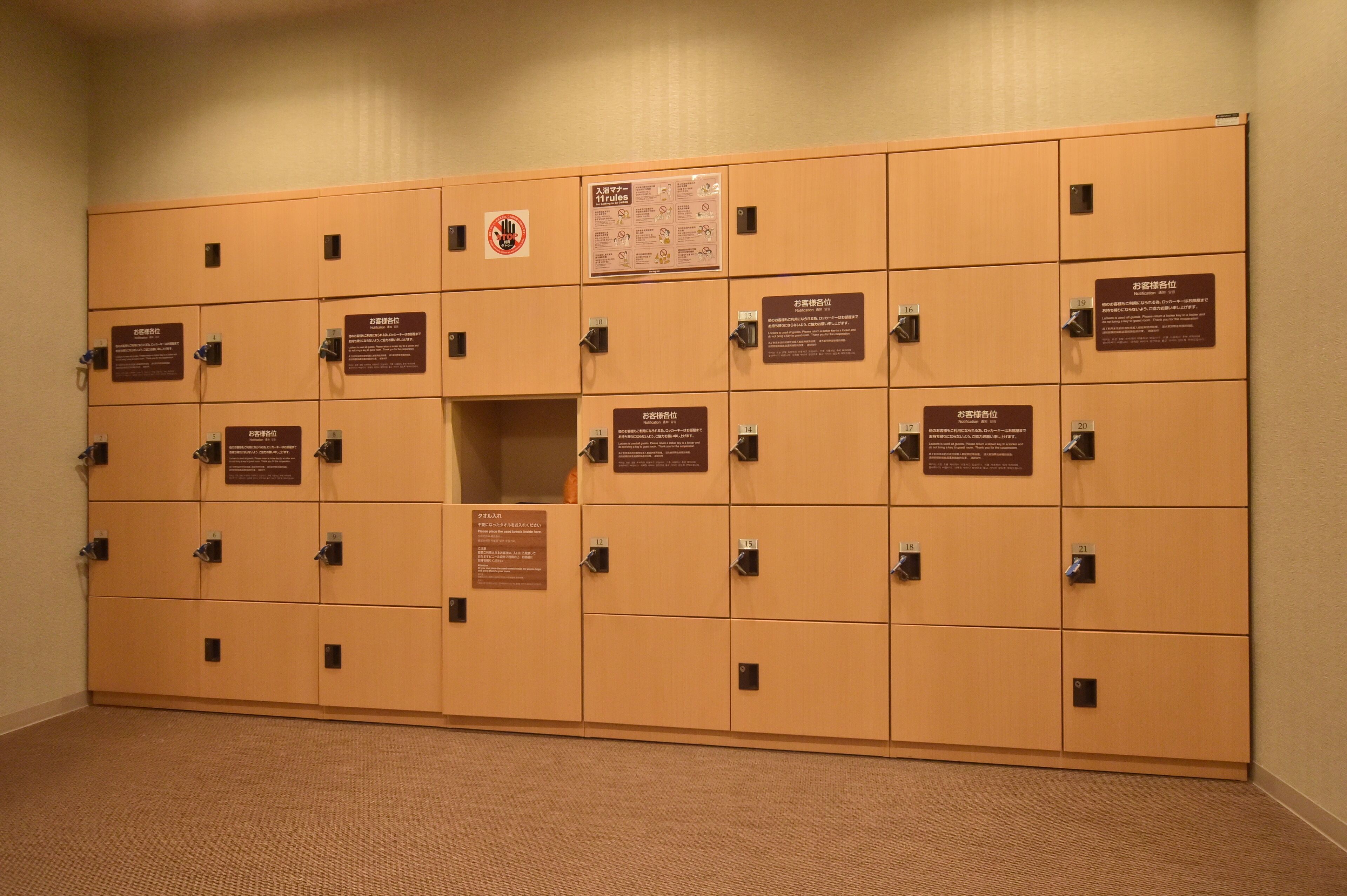 A row of wooden lockers with numbered labels and informational signs.