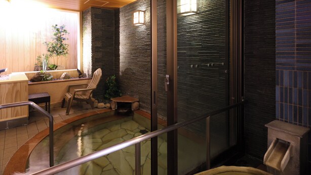 A hot tub area with a stone floor, wooden seating, and a glass partition. - Dormy Inn Sapporo Annex Hot Spring (Sapporo)