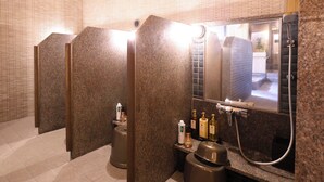 A public restroom with granite walls, a mirror, and a shower. - Dormy Inn Sapporo Annex Hot Spring (Sapporo)