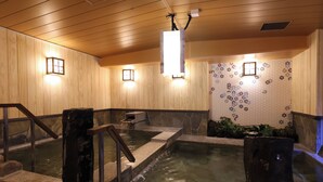 A traditional Japanese onsen with wooden walls, stone steps, and tiled walls. - Dormy Inn Sapporo Annex Hot Spring (Sapporo)