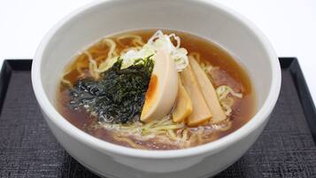 A bowl of ramen with noodles, seaweed, and a slice of egg.