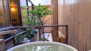 A wooden interior with a hot spring bath, wooden railings, and a small tree. - Dormy Inn PREMIUM Sapporo Hot Spring (Sapporo)