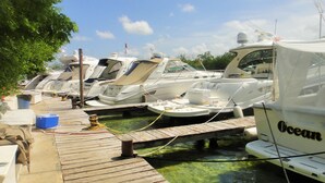 A marina with several boats docked, wooden walkways, and a clear sky. - Hotel Sotavento & Yacht Club (Cancun)