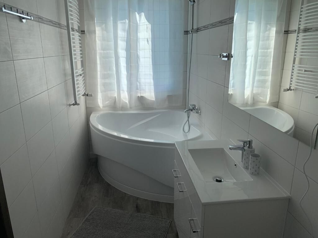 A modern bathroom with a freestanding bathtub, a vanity with a sink, and a shower area.