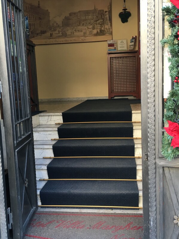 A staircase with black carpeted steps leading to a door. - Villa Margherita (Naples)