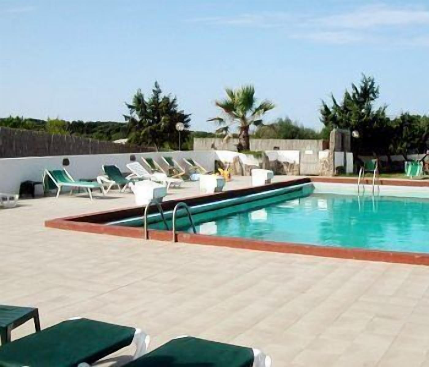 A pool area with lounge chairs and a swimming pool.