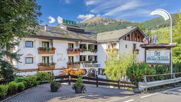 Ein Hotel mit Schild, das es als Residenz kennzeichnet, umgeben von üppiger Vegetation und einer Bergkulisse.
