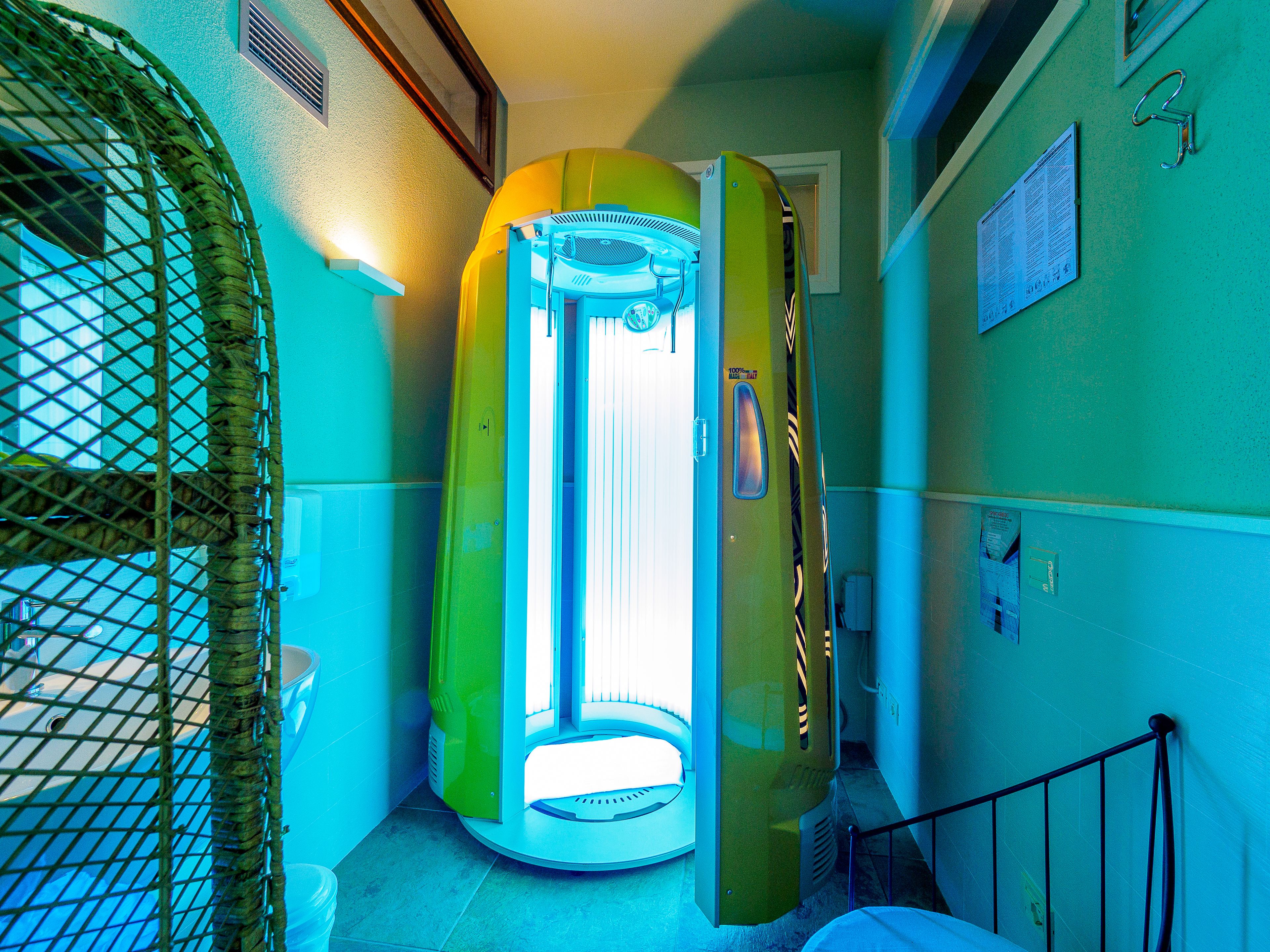 A room with a large, enclosed, cylindrical device, possibly a sauna or therapy room, with a door open.
