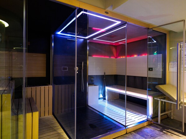 A glass-walled sauna with a wooden bench and a control panel. - Hotel Sant Anton (Bormio)
