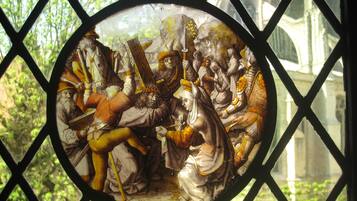 A stained glass window with a historical scene.