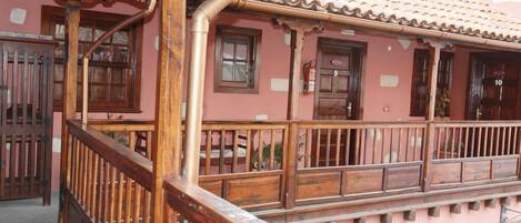 Un bâtiment doté d’un balcon en bois et d’un toit recouvert de tuiles.