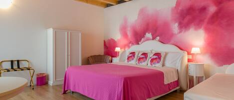 Un dormitorio con una cama grande, techo de madera y pintura rosa en la pared.