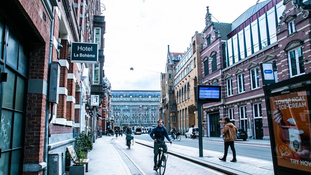 A hotel named "Hotel La Bohème" with a traditional European architectural style, located on a city street with pedestrians and cyclists. - La Boheme (Amsterdam)