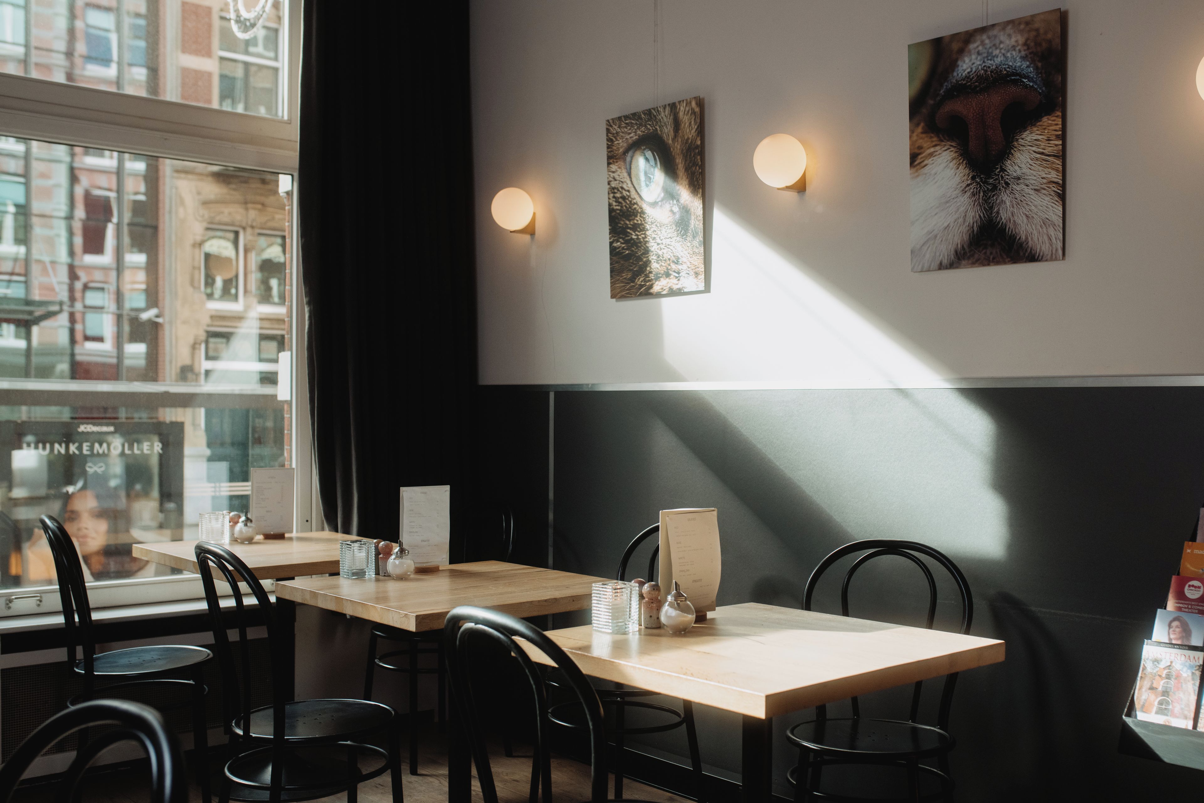 A restaurant interior with tables, chairs, and wall-mounted artwork.