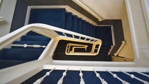 A staircase with blue carpeted steps and white handrails. - La Boheme (Amsterdam)
