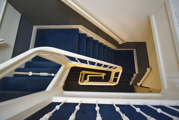 A staircase with blue carpeted steps and white handrails. - La Boheme (Amsterdam)