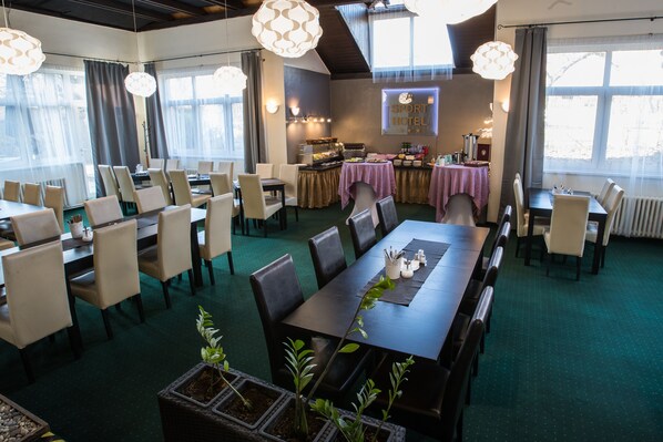 A hotel dining area with multiple tables and chairs, a buffet setup, and a sign indicating it's a sport hotel. - A-Sport Hotel (Brno)