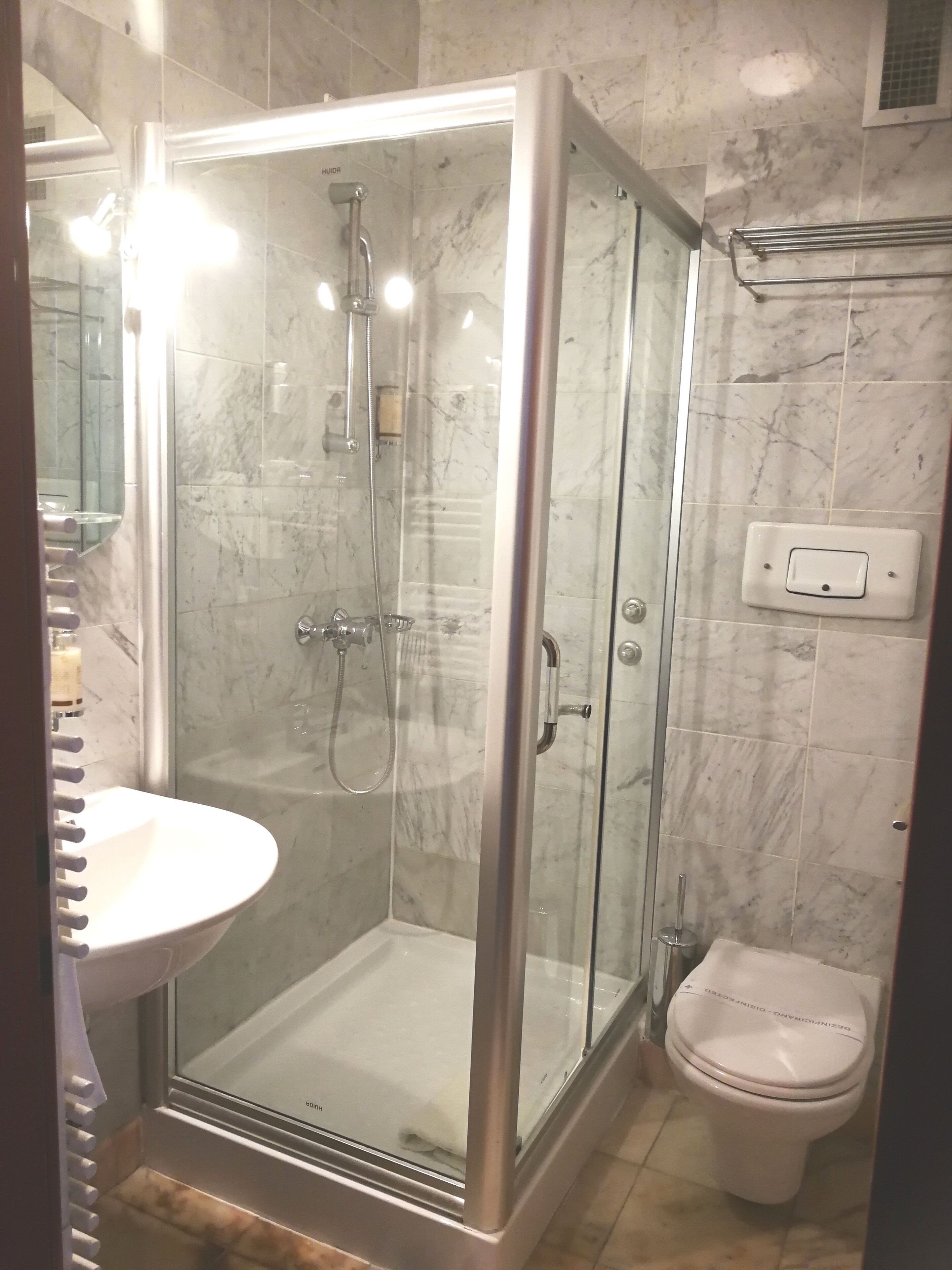 Une salle de bain moderne avec une douche à parois de verre, un lavabo blanc et des toilettes.