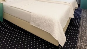 Une chambre d’hôtel avec un grand lit, un bureau, une chaise, un tableau et une fenêtre avec des rideaux.