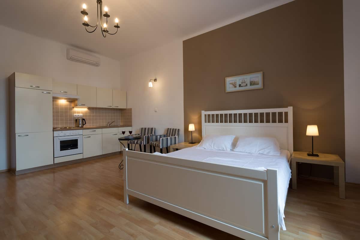 Una camera da letto con un letto, un comodino, una lampada e un tavolino con sedie.